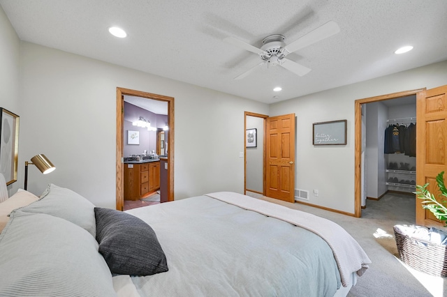 7111 Trenton Ln N, Maple Grove, MN 55369 - bedroom featuring light colored carpet, a walk in closet, recessed lighting, connected bathroom, and a ceiling fan