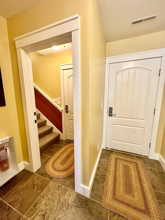 6940 Beach View Ln NW Unit 220-1, Walker, MN 56484 - tiled entryway featuring stairway and baseboards