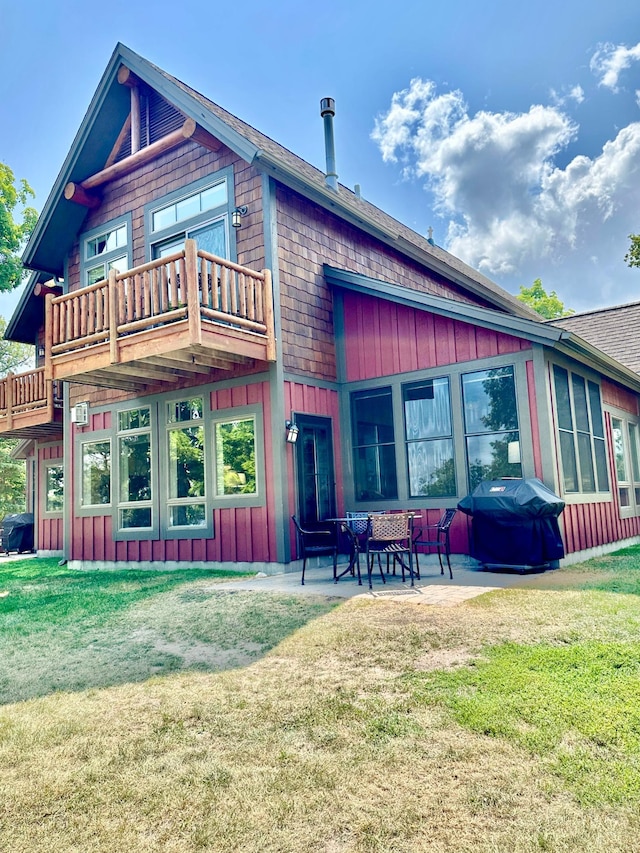 6940 Beach View Ln NW Unit 220-1, Walker, MN 56484 - rear view of property featuring a balcony, board and batten siding, a yard, a patio, and a shingled roof
