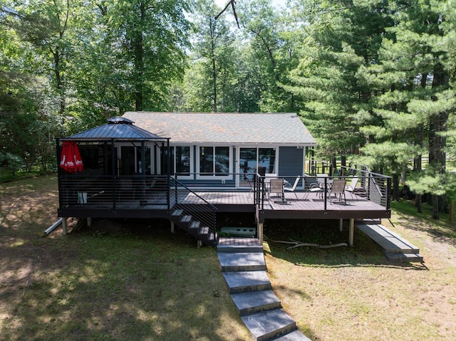 N2590 Warren Rd, Madge Twp, WI 54870 - back of property with a wooden deck, a gazebo, roof with shingles, a lawn, and view of wooded area