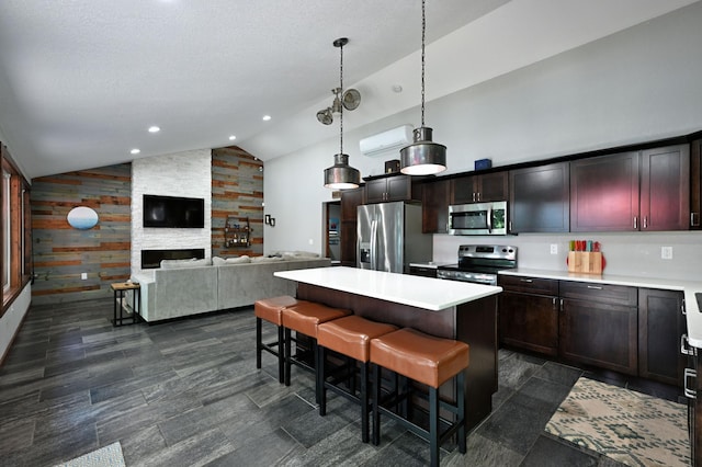 N2590 Warren Rd, Madge Twp, WI 54870 - kitchen featuring stainless steel appliances, lofted ceiling, light countertops, a kitchen island, and decorative light fixtures