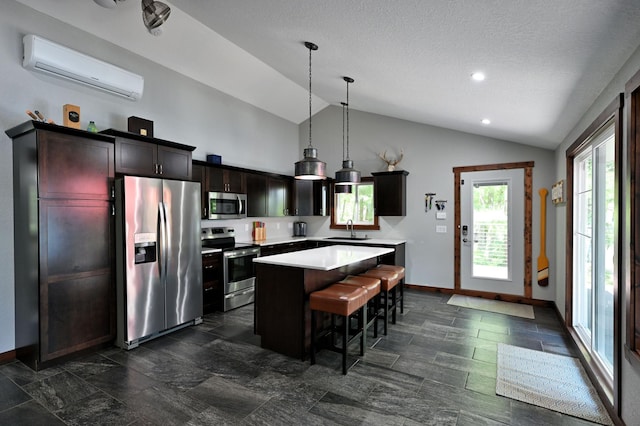 N2590 Warren Rd, Madge Twp, WI 54870 - kitchen featuring stainless steel appliances, a wall unit AC, lofted ceiling, a kitchen island, and light countertops