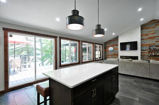 N2590 Warren Rd, Madge Twp, WI 54870 - kitchen with lofted ceiling, wood walls, light countertops, hanging light fixtures, and a center island