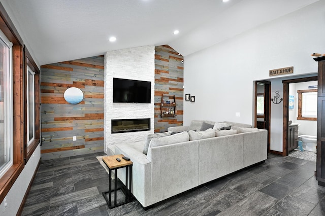 N2590 Warren Rd, Madge Twp, WI 54870 - living room featuring wooden walls, a stone fireplace, and high vaulted ceiling