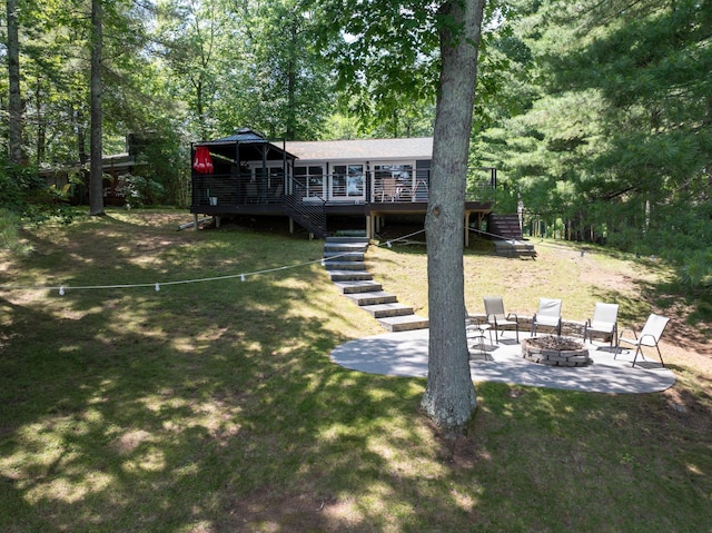 N2590 Warren Rd, Madge Twp, WI 54870 - rear view of house with a fire pit, stairs, a wooden deck, and a yard