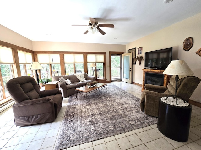 21200 5th St NW, Colfax Twp, MN 56273 - living area with tile patterned floors, a ceiling fan, and a glass covered fireplace