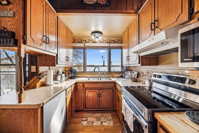 13235 80th St NW, Annandale, MN 55302 - kitchen with appliances with stainless steel finishes, light countertops, under cabinet range hood, wood finished floors, and brown cabinetry