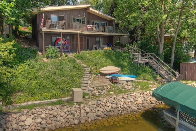13235 80th St NW, Annandale, MN 55302 - rear view of house with stairway, a wooden deck, and board and batten siding