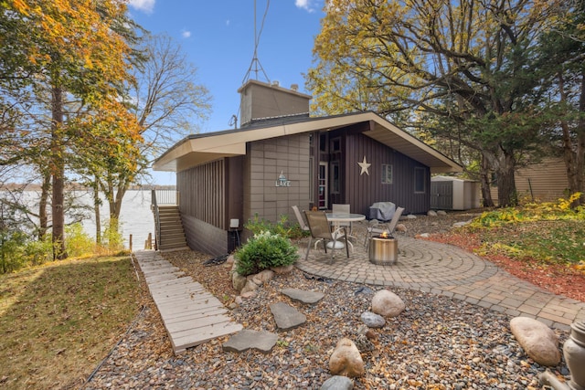 13235 80th St NW, Annandale, MN 55302 - rear view of property with a patio, a chimney, and board and batten siding