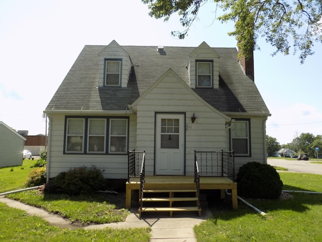 411 Bush St, Lakefield, MN 56150 - new england style home featuring a chimney, a deck, a front lawn, and a shingled roof