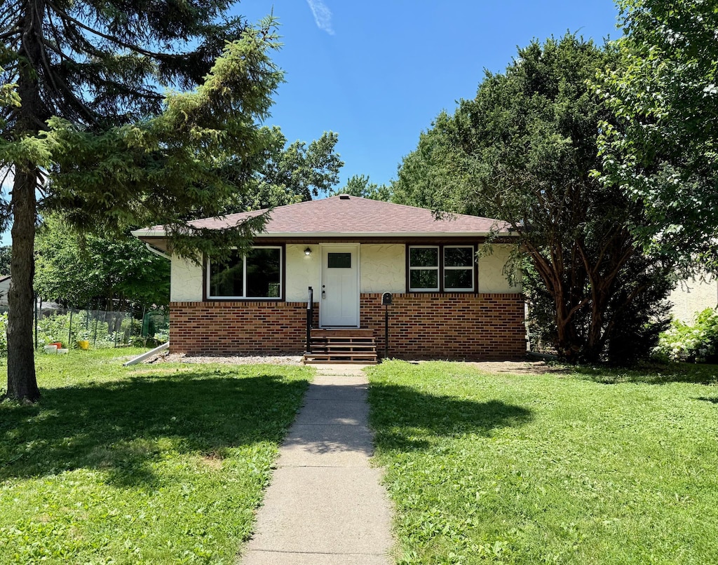 3541 Kyle Ave N, Crystal, MN 55422 - bungalow-style house with brick siding, a front yard, and stucco siding