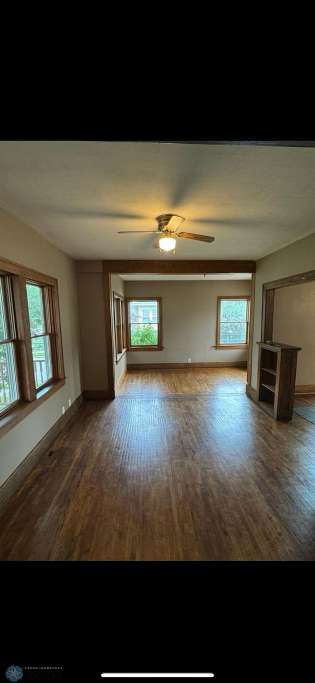 802 11th Ave N, Fargo, ND 58102 - unfurnished living room with wood finished floors, plenty of natural light, and ceiling fan