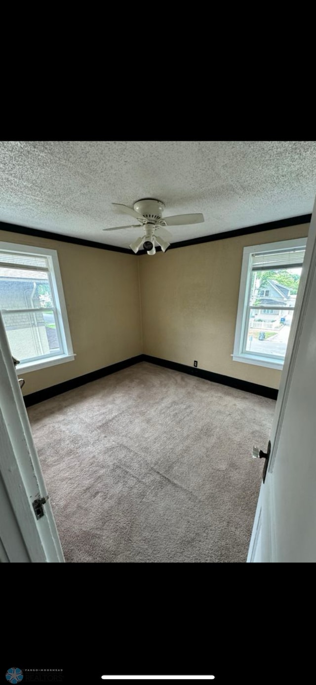 802 11th Ave N, Fargo, ND 58102 - carpeted spare room with healthy amount of natural light, a textured ceiling, and a ceiling fan