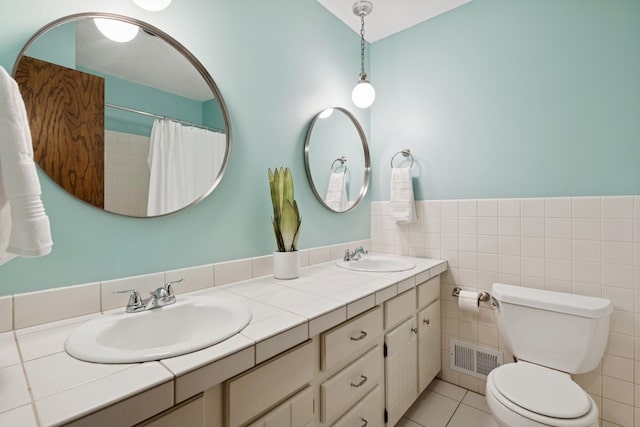 10316 Zinran Ave S, Bloomington, MN 55438 - bathroom featuring double vanity, tile patterned floors, a shower with curtain, and tile walls