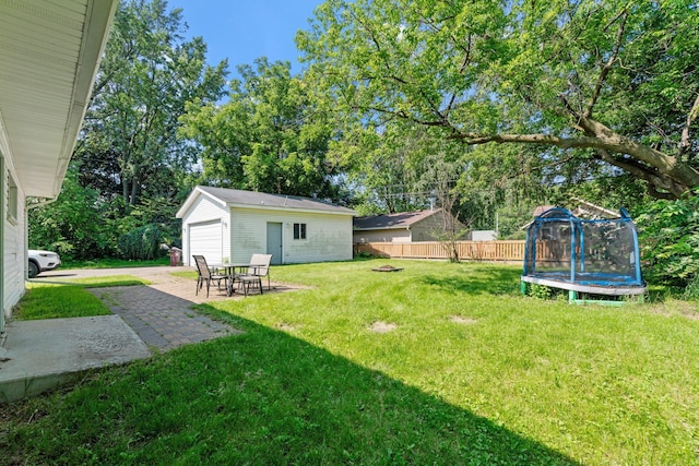 905 Bellows St, West Saint Paul, MN 55118 - view of yard with a trampoline, an outdoor structure, a garage, view of scattered trees, and a patio area