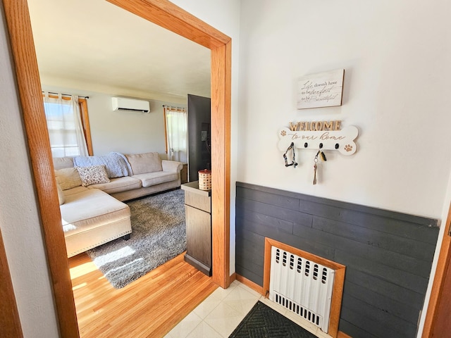 460 3rd St, Bird Island, MN 55310 - living room featuring radiator heating unit, a wall mounted air conditioner, and wood walls