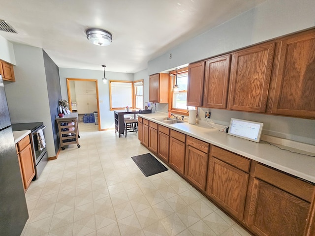 460 3rd St, Bird Island, MN 55310 - kitchen featuring brown cabinetry, light flooring, stainless steel range with electric stovetop, light countertops, and beverage cooler