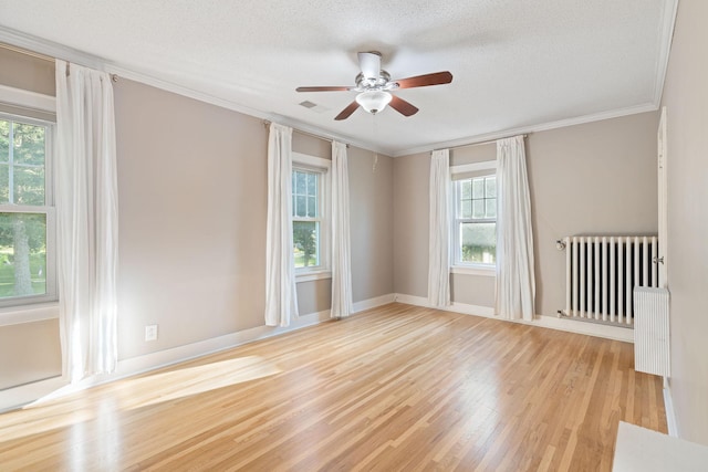 506 6th Ave SW, Austin, MN 55912 - empty room with radiator heating unit, wood finished floors, ceiling fan, crown molding, and a textured ceiling