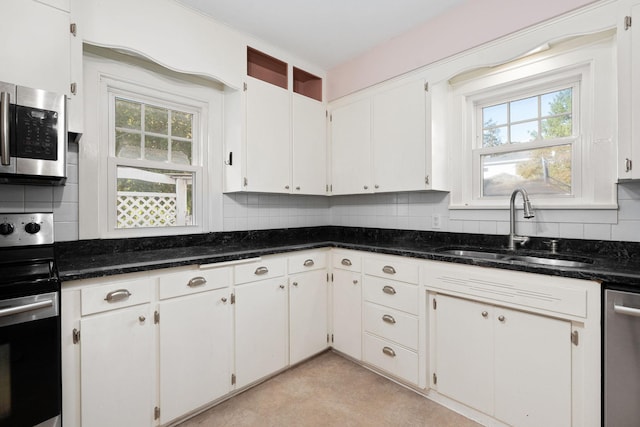 506 6th Ave SW, Austin, MN 55912 - kitchen with stainless steel appliances, backsplash, dark stone countertops, and white cabinets