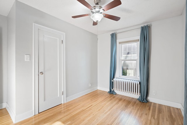 506 6th Ave SW, Austin, MN 55912 - unfurnished room featuring radiator, wood finished floors, and a ceiling fan