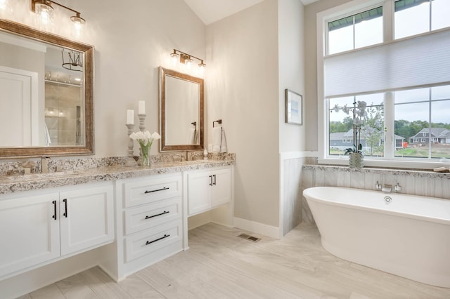 3163 Christopher Ln, Shoreview, MN 55126 - full bathroom featuring double vanity, a soaking tub, a shower stall, and a wainscoted wall