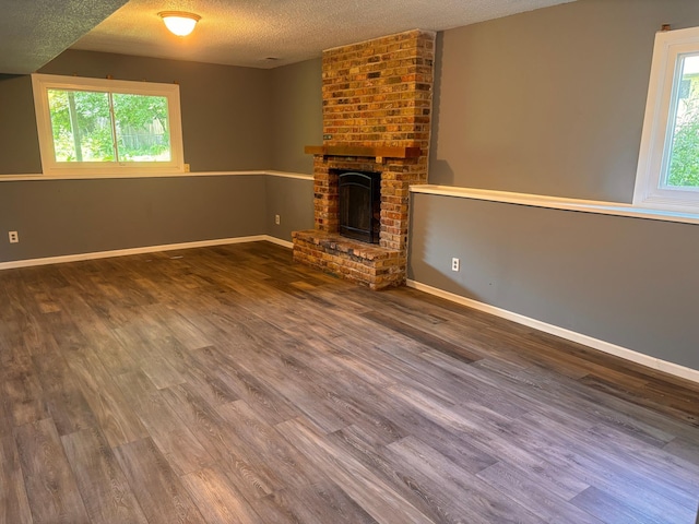 2905 Flag Ave N, New Hope, MN 55427 - unfurnished living room with a textured ceiling, wood finished floors, and a brick fireplace
