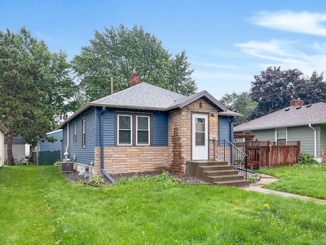 1502 Maywood St, Saint Paul, MN 55117 - view of front facade featuring stone siding, a shingled roof, and a chimney