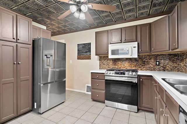 1502 Maywood St, Saint Paul, MN 55117 - kitchen with appliances with stainless steel finishes, backsplash, light tile patterned flooring, a ceiling fan, and an ornate ceiling