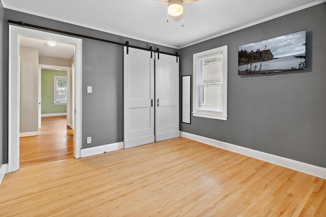 1502 Maywood St, Saint Paul, MN 55117 - unfurnished bedroom with a barn door, wood finished floors, crown molding, multiple windows, and ceiling fan