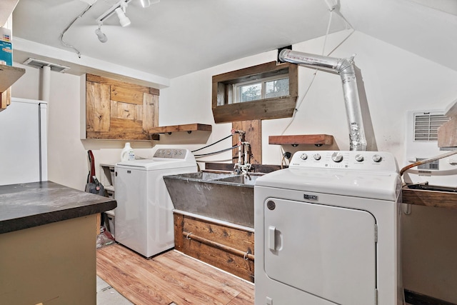 1502 Maywood St, Saint Paul, MN 55117 - laundry area featuring washing machine and clothes dryer, cabinet space, light wood finished floors, and rail lighting