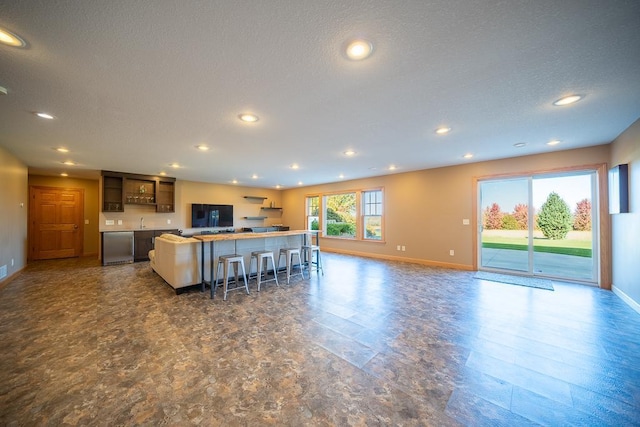 35337 County 24th Blvd, Warsaw Twp, MN 55009 - kitchen featuring a kitchen island, recessed lighting, open floor plan, a textured ceiling, and a kitchen bar