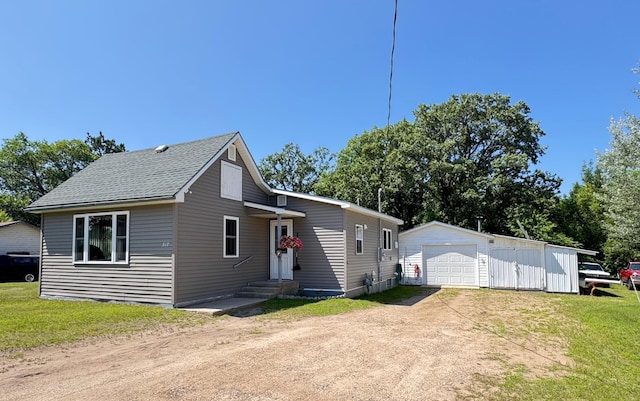 317 2nd St NE, Menahga, MN 56464 - view of front of house featuring driveway, a garage, an outdoor structure, and a front lawn