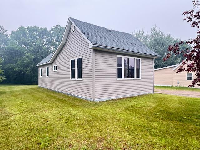 317 2nd St NE, Menahga, MN 56464 - view of side of property with a yard and roof with shingles
