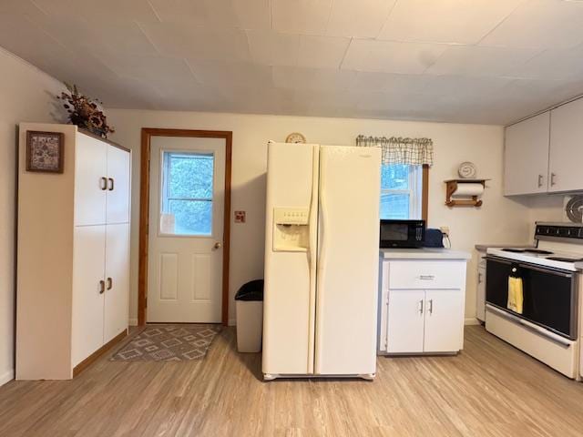317 2nd St NE, Menahga, MN 56464 - kitchen with white appliances, light wood-type flooring, healthy amount of natural light, and white cabinetry