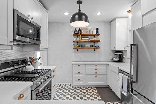 5712 Grand Ave S, Minneapolis, MN 55419 - kitchen featuring stainless steel appliances, dark floors, light countertops, white cabinets, and hanging light fixtures