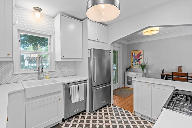 5712 Grand Ave S, Minneapolis, MN 55419 - kitchen with appliances with stainless steel finishes, white cabinets, light countertops, backsplash, and light flooring