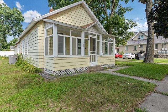 515 Lincoln St, Winona, MN 55987 - view of front of house with a chimney, entry steps, a sunroom, and a front lawn