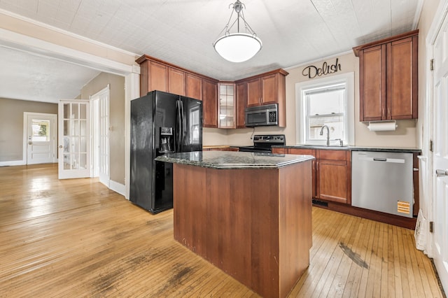 515 Lincoln St, Winona, MN 55987 - kitchen featuring appliances with stainless steel finishes, light wood finished floors, a center island, brown cabinetry, and crown molding