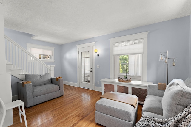 3502 Grand Ave S, Minneapolis, MN 55408 - living room featuring stairway, light wood finished floors, and a textured ceiling
