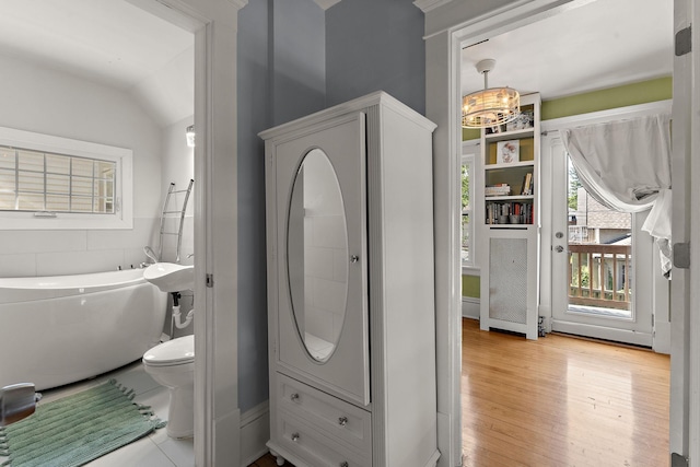 3502 Grand Ave S, Minneapolis, MN 55408 - bathroom with a bathtub, a chandelier, wood finished floors, and vaulted ceiling