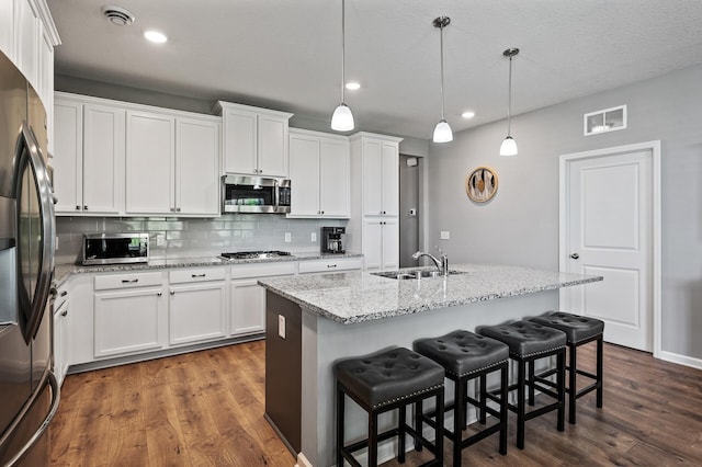 4870 Copper Ridge Dr, Woodbury, MN 55129 - kitchen featuring appliances with stainless steel finishes, decorative backsplash, dark wood-type flooring, white cabinets, and recessed lighting