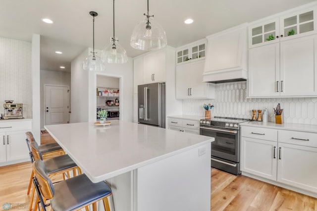 6176 Marigold Loop S, Fargo, ND 58104 - kitchen featuring appliances with stainless steel finishes, premium range hood, a kitchen island, light wood finished floors, and recessed lighting