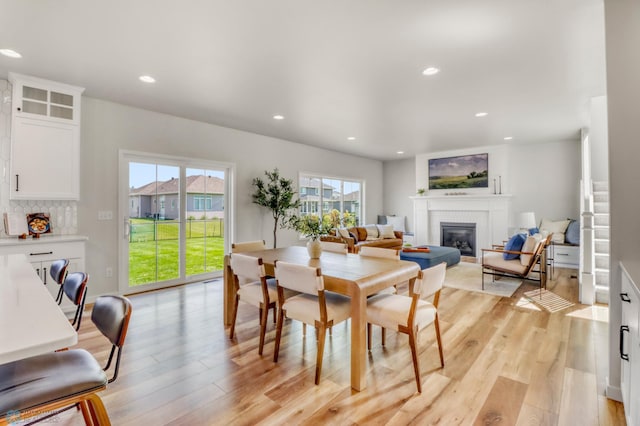 6176 Marigold Loop S, Fargo, ND 58104 - dining area featuring a glass covered fireplace, light wood-type flooring, and recessed lighting