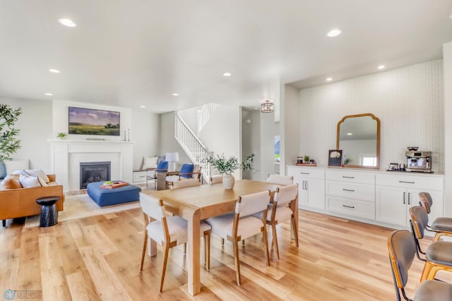 6176 Marigold Loop S, Fargo, ND 58104 - dining space featuring stairs, light wood-type flooring, recessed lighting, and a glass covered fireplace