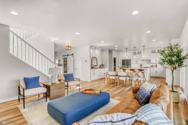 6176 Marigold Loop S, Fargo, ND 58104 - living room featuring a barn door, stairs, recessed lighting, and light wood-type flooring