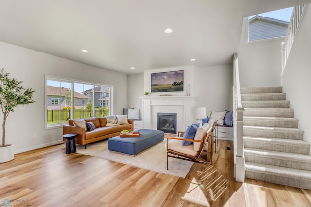6176 Marigold Loop S, Fargo, ND 58104 - living room featuring stairs, light wood-style floors, a glass covered fireplace, and recessed lighting
