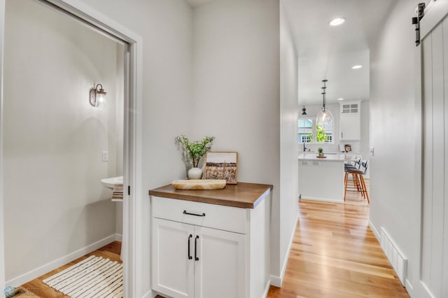 6176 Marigold Loop S, Fargo, ND 58104 - hallway with a barn door, light wood-type flooring, and recessed lighting