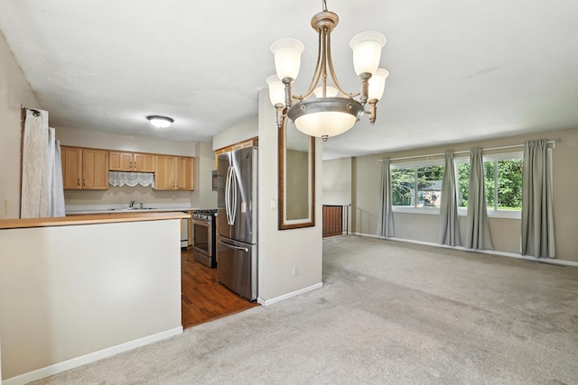 1958 6th St N, North Saint Paul, MN 55109 - kitchen featuring stainless steel appliances, carpet, light countertops, open floor plan, and pendant lighting