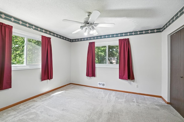 1958 6th St N, North Saint Paul, MN 55109 - empty room featuring healthy amount of natural light, a textured ceiling, carpet, and ceiling fan