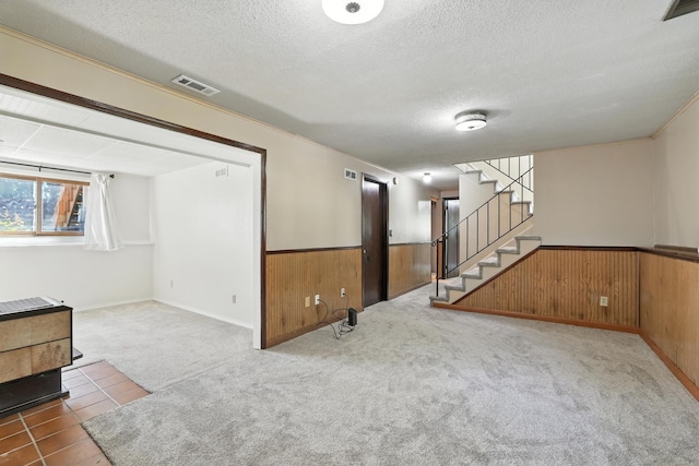 1958 6th St N, North Saint Paul, MN 55109 - basement with wainscoting, wood walls, a textured ceiling, stairway, and carpet